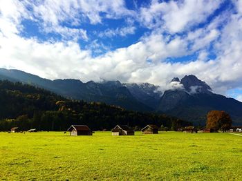 Houses on countryside landscape against mountain range