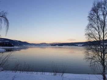 Scenic view of lake against clear sky during winter