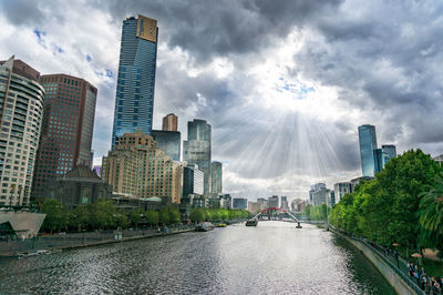 Epic cityscape of melbourne southbank and yarra river with sun rays shining through the clouds