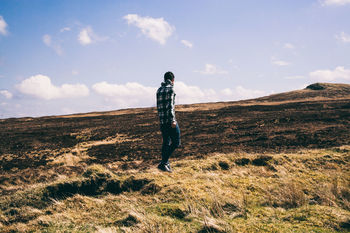 Full length of man walking on field against sky