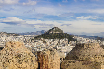 Aerial view of city against cloudy sky