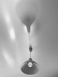 Low angle view of light bulb hanging on ceiling