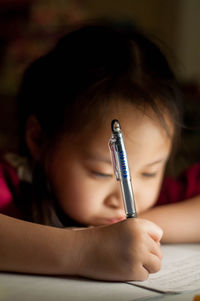 Close-up of girl writing in book