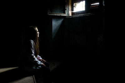 Woman sitting in darkroom