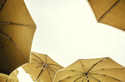 Low angle view of parasols against clear sky