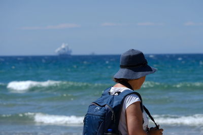 Woman looking at sea against sky