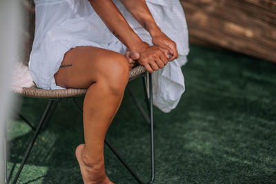 Low section of woman sitting on chair