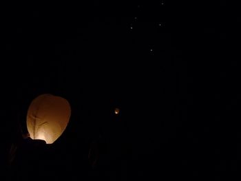 Low angle view of illuminated lantern against sky at night