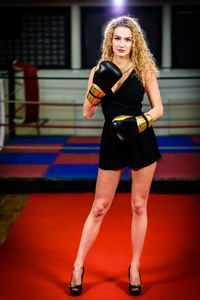 Portrait of beautiful young woman wearing gloves while standing on red carpet