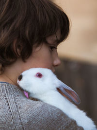 Close-up of girl embracing rabbit