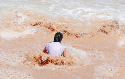 Rear view of woman standing on beach