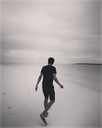 Rear view of man walking on beach