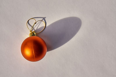 Close-up of orange heart shape on table against wall