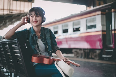 Beautiful young woman standing by train