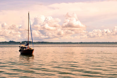 Sailboat sailing on sea against sky during sunset