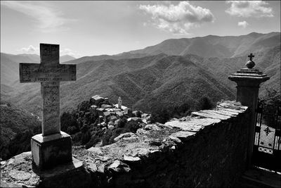 Cemetery cross on mountain against sky