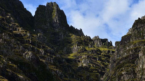 Low angle view of mountain against cloudy sky