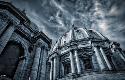 Low angle view of st peter basilica against cloudy sky