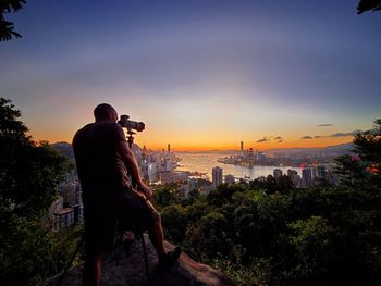 Side view of man standing against sky during sunset