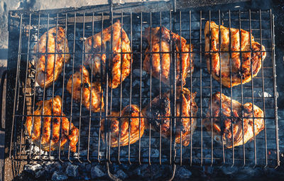 Mouthwatering chicken drumsticks roasting on an open flame, culinary work of art