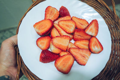 High angle view of hand holding strawberries