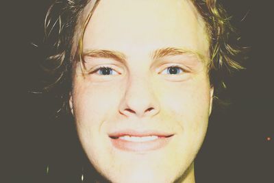 Portrait of young woman against black background