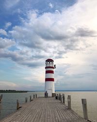 Lighthouse by sea against sky