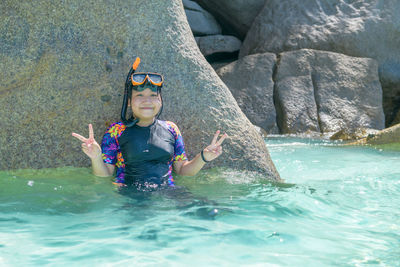 Happy cute girl with face masks and snorkels, sea in background. recreation in summer