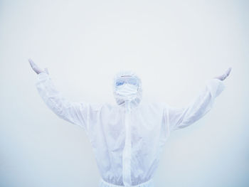 Man with arms raised against white background