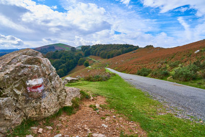 Road amidst green landscape against sky