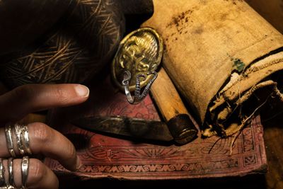 Cropped hand of man holding wine bottle on table