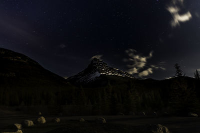 Scenic view of snowcapped mountains against sky at night