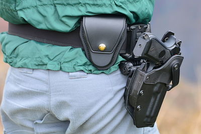 Midsection of man holding camera at home