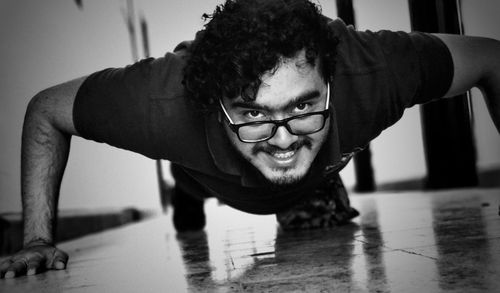 Portrait of young man exercising on floor