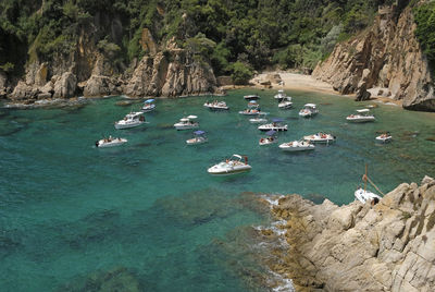 Various boats on the clear water in a calm bay along the costa brava near lloret de mar, spain.