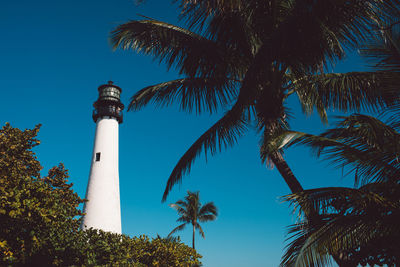 Lighthouse by sea against sky