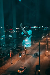 Man with umbrella on road at night