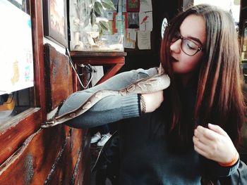 Young woman holding snake