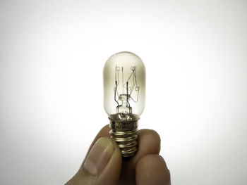 Close-up of light bulb against white background