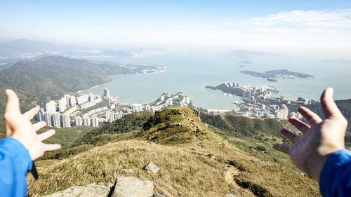 Low section of people on mountain against sky