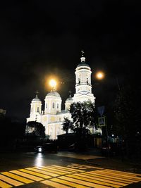 Low angle view of illuminated street light against building at night