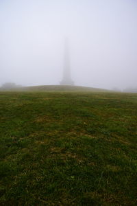 Scenic view of grassy field against sky