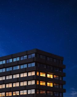 Low angle view of building against blue sky at night