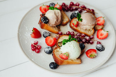 Close-up of ice cream with fruits and breads in plate on table