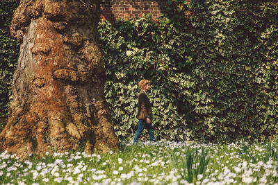 Side view of young woman walking in park