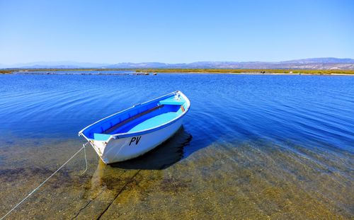 Close-up of boat in sea against clear blue sky