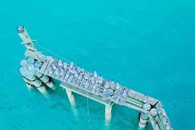 High angle view of seagulls perching on broken jetty over sea