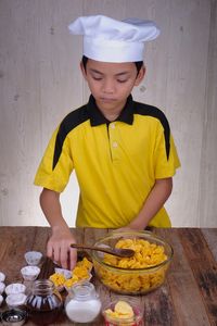 Boy preparing food on table at home