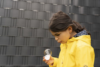 Portrait of boy standing against wall