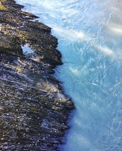 High angle view of sea waves splashing on rocks